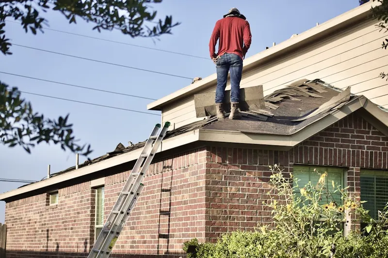 Professional roofer working on a residential roof in Milton Center